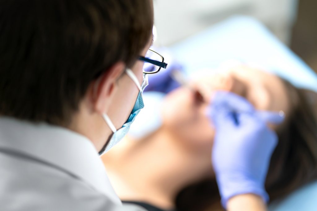 Close-up of a dentist performing a dental procedure on a patient.